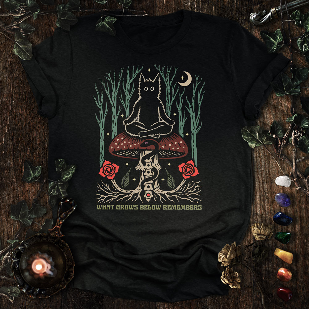 Root Chakra Cat T-Shirt design featuring a meditating black cat on a mushroom with a bone spine, glowing root chakra, and mystical forest elements.