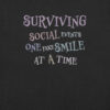 T-shirt with the phrase “Fake Smile” in soft, understated tones — a quiet nod to social exhaustion.