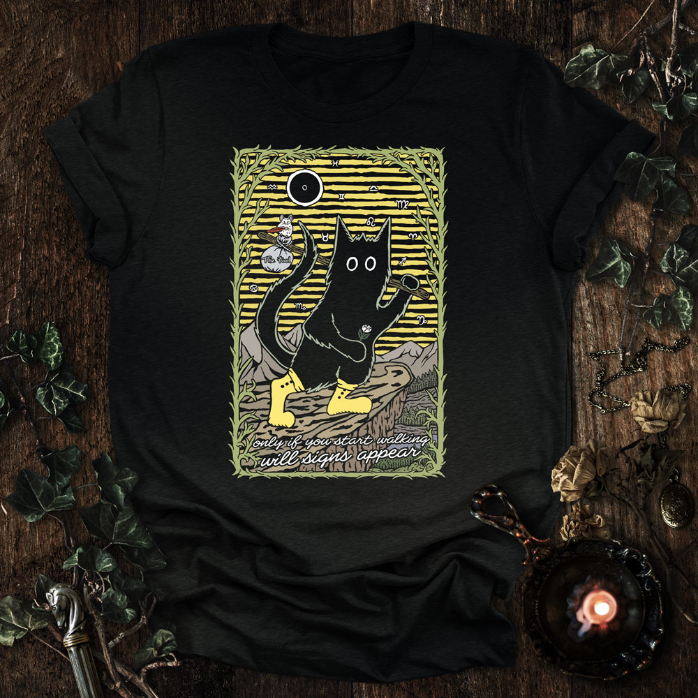 The Fool Tarot Cat T-Shirt featuring a black cat stepping forward, symbolizing trust, beginnings, and movement into the unknown.