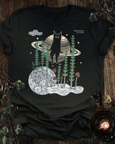 Horsetail cat t-shirt featuring a contemplative cat seated on Saturn above the Moon with horsetail, mushrooms, and symbolic botanical elements.